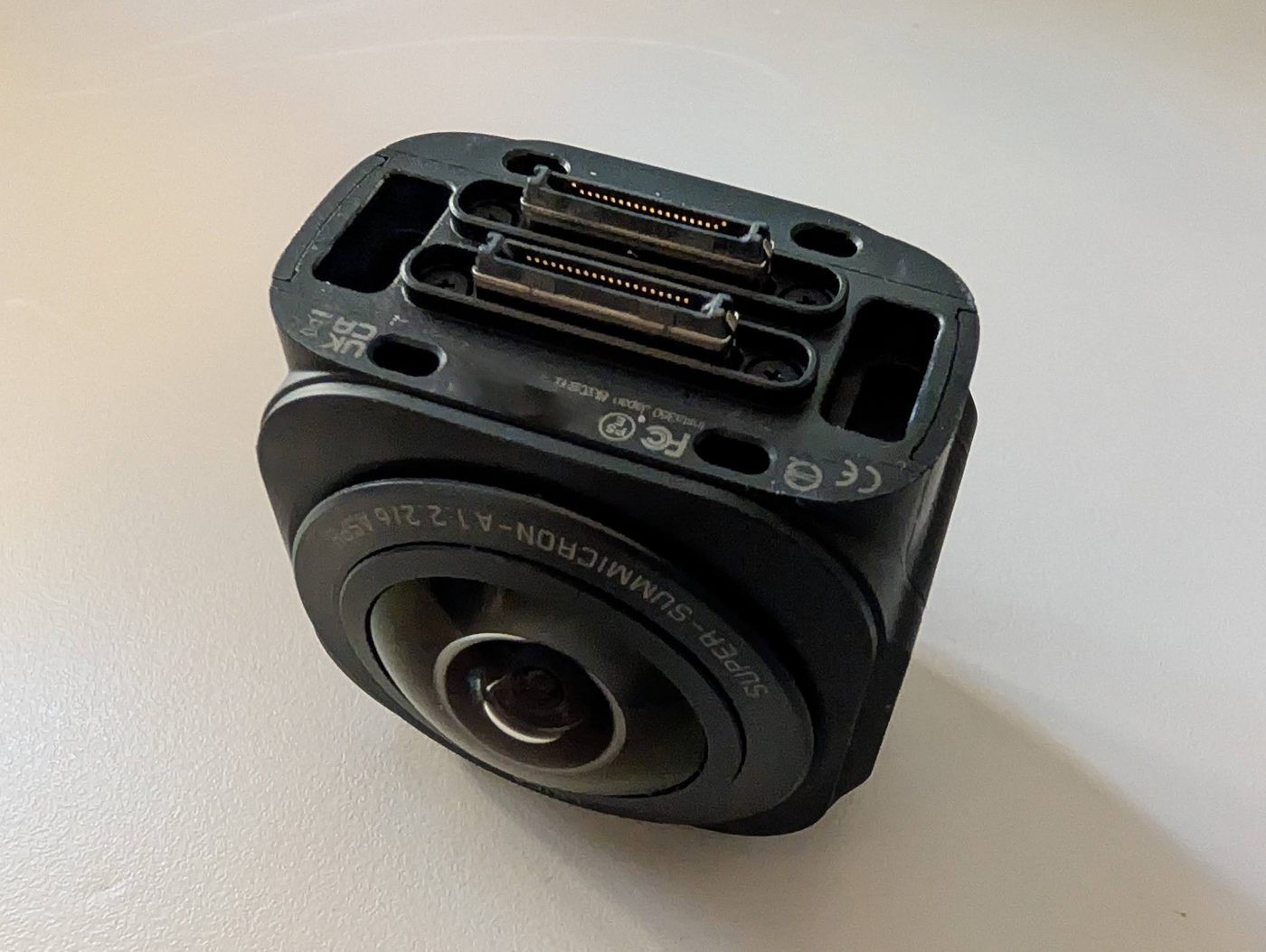 The underside of the Insta360 One RS 1-inch core, showing the spring-contact strip and rails the discontinued battery used to clip onto