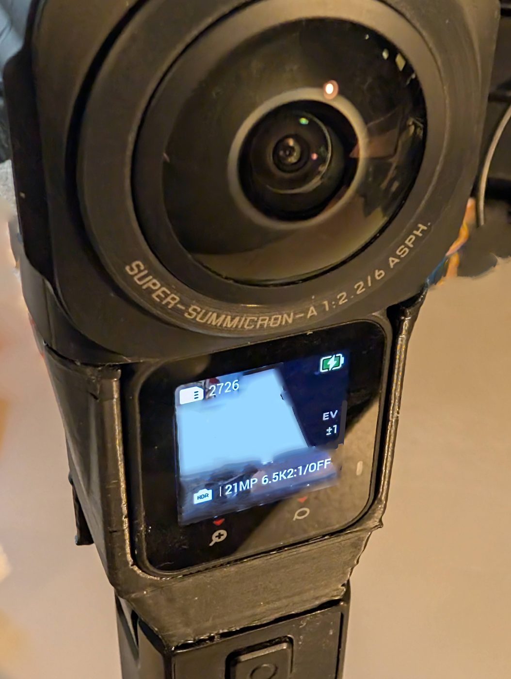 The assembled camera powered on, screen lit, Leica Super-Summicron 360 lens in the foreground